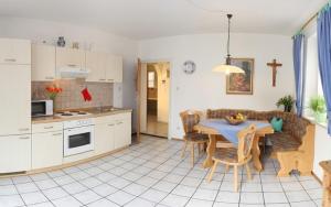 Una cocina y una sala de estar con una mesa y un sofá. en Ferienwohnung Genzinger, en Bernau am Chiemsee