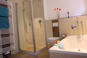 Un baño con ducha, bañera y WC. en Ferienwohnung Genzinger, en Bernau am Chiemsee