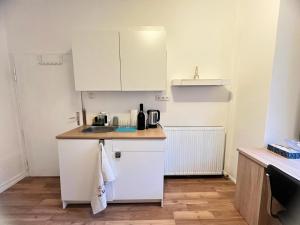 ビーティッヒハイム・ビッシンゲンにあるBietigheim-Bissingen Studios, Zimmer und Appartement'sの白いキャビネットとシンクを備えた小さなキッチン +1枚の写真