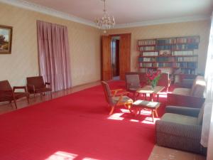 ein Wohnzimmer mit Stühlen und einem roten Teppich in der Unterkunft apartament in Sugdidi