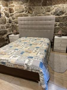 a bedroom with a bed with a stone wall at Casa do Pátio - Férias no Douro in Baião +17 photos