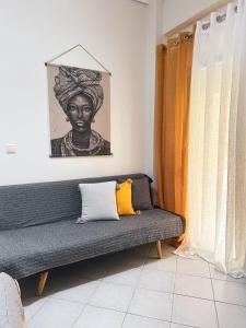 kanapę w salonie z portretem kobiety w obiekcie Efrosini downtown apartment w Chalkidzie
