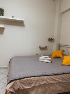 łóżko z żółtymi poduszkami i ręcznikami w obiekcie Efrosini downtown apartment w Chalkidzie