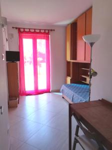 una camera con porta rossa e una camera con tavolo di Alloggio Turistico Castel di Leva a Castel di Leva