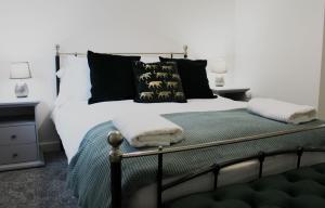 - une chambre dotée d'un grand lit avec des oreillers noirs et verts dans l'établissement Didcot - Private Flat with Garden & Parking 08, à Didcot
