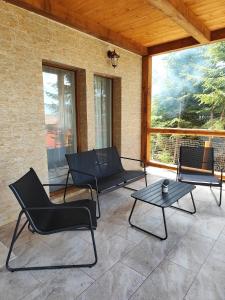a patio with chairs and a table on a porch at Woodland house ** in Sântimbru-Băi +7 photos