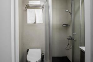 a bathroom with a toilet and a shower with towels at İstanbul Efes Hotel in Istanbul