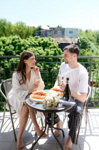 un uomo e una donna seduti a un tavolo con bicchieri da vino di Nota Bene Hotel & Restaurant a Lviv