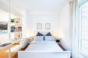 una camera da letto bianca con un letto e una scrivania di Appartamento 3pax a Ponte Milvio a Roma