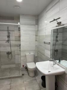 uma casa de banho com um WC, um lavatório e um chuveiro em Seaside apartments em Batumi