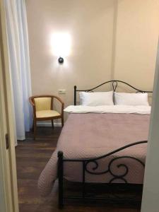 um quarto com uma cama, uma cadeira e um candeeiro em Seaside apartments em Batumi