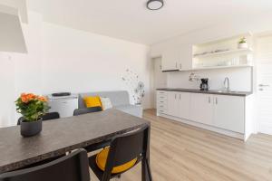 a kitchen with white cabinets and a table and chairs at Apartma Lajf in Brežice +10 photos