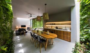 cocina y sala de estar con mesa de madera y sillas en Villa Wyndham Phu Quoc en Phu Quoc