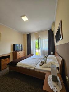 Un dormitorio con una cama y una mesa con una tablet. en Bed and Breakfast Restaurant DP, en Donji Zvečaj