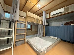 a room with a bed and bunk beds in it at すくもBOX in Sukumo