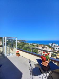 balcone con tavolo, sedie e vista sull'oceano di Holidays Cefalù a Cefalù