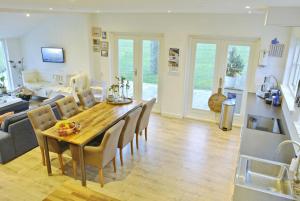 a kitchen and living room with a table and chairs at Druvebeam in Oudega