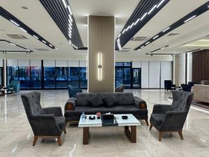 a lobby with a couch and two chairs and a table at Banoj Hotel in Erbil