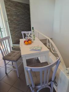 een witte tafel met fruit erop met twee stoelen bij House Al Noce in Moltrasio