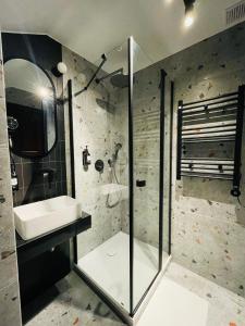 ein Bad mit einer Glasdusche und einem Waschbecken in der Unterkunft Hotel Millennium in Przasnysz