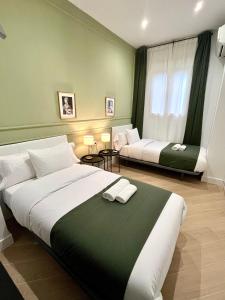 um quarto grande com 2 camas e uma janela em Apartamentos Élite - Art Collection - Leonardo em Mérida