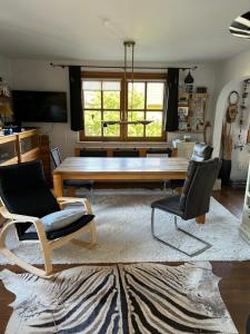 uma sala de estar com uma mesa de madeira e cadeiras em Evis Cottage em Wertheim