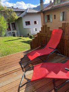 einem roten Stuhl auf einer Holzterrasse in der Unterkunft Appartement Saint-Gervais-Les-Bains in Saint-Gervais-les-Bains