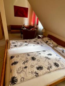 two twin beds in a room with a table at Pension Kolibri in Hemmoor