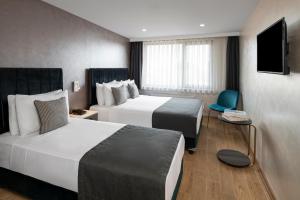 pokój hotelowy z 2 łóżkami i telewizorem w obiekcie İstanbul Efes Hotel w Stambule