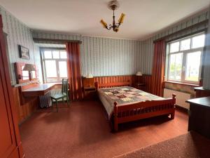 a bedroom with a bed and a desk and window at Janune Kägu in Koeru +2 photos