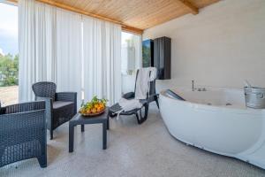 ein Bad mit einer Badewanne, einem Tisch und Stühlen in der Unterkunft Villa Rosa con accesso sul mare in Pachino