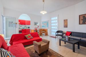 ein Wohnzimmer mit einem roten Sofa und einem Tisch in der Unterkunft Villa Rosa con accesso sul mare in Pachino