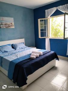 a bedroom with a bed with blue walls and a window at LA TERRAZZA SUL MARE camera fronte mare&vicino aereoporto SICILIAN VINTAGE STYLE SEASIDE ROOM in Cinisi +44 photos