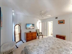 a bedroom with a bed and a dresser and a mirror at Beachfront oasis, heated pool and garden view #17 in Marathon +41 photos