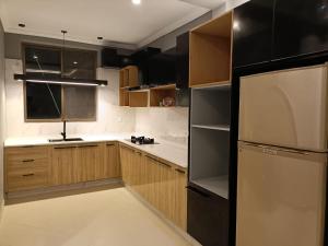 a kitchen with wooden cabinets and a refrigerator at Royal Lodge By Hotel Demanchi in Murree
