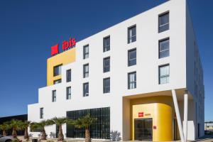 a white building with a n bits sign on it at Ibis Marseille Marignane Technopole in Marignane