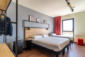 1 dormitorio con 2 camas y ventana en Ibis Marseille Marignane Technopole, en Marignane
