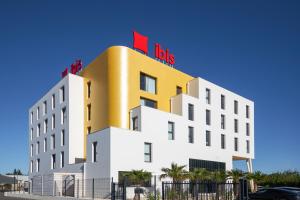 マリニャーヌにあるIbis Marseille Marignane Technopoleの赤い看板が上のホテル