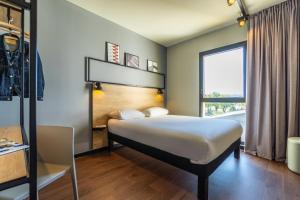 een slaapkamer met een bed en een raam bij Ibis Marseille Marignane Technopole in Marignane