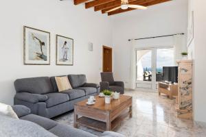 a living room with a couch and a coffee table at Villa Panorama in Cala'n Porter