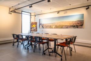 einen Tisch und Stühle in einem Zimmer mit einem Gemälde an der Wand in der Unterkunft Ibis Marseille Marignane Technopole in Marignane