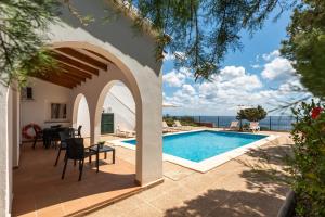 a villa with a swimming pool and a patio at Villa Panorama in Cala'n Porter