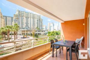 a balcony with a table and chairs and a view of a city at Apartamento Racodifach 2B - Grupo Turis in Calpe