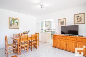 a living room with a dining room table and a television at Apartamento Racodifach 2B - Grupo Turis in Calpe