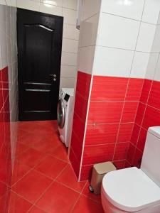 Un baño rojo con inodoro y puerta negra. en Edi's Apartments-Cozy stay in the center, en Tirana 24 fotos más