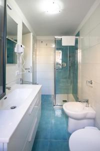 Un baño con inodoro, lavabo y ducha. en Terrazza Sanfelice, en Agropoli