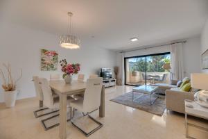 a dining room and living room with a table and chairs at 2-bed apartment in Capanes del Golf in Benahavís