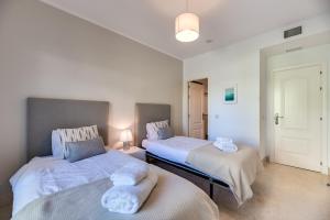 a bedroom with two beds with towels on them at 2-bed apartment in Capanes del Golf in Benahavís +23 photos