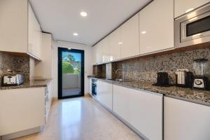 a kitchen with white cabinets and granite counter tops at 2-bed apartment in Capanes del Golf in Benahavís