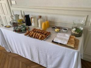una mesa con pan y otros alimentos. en Château du Mont de Guny, 